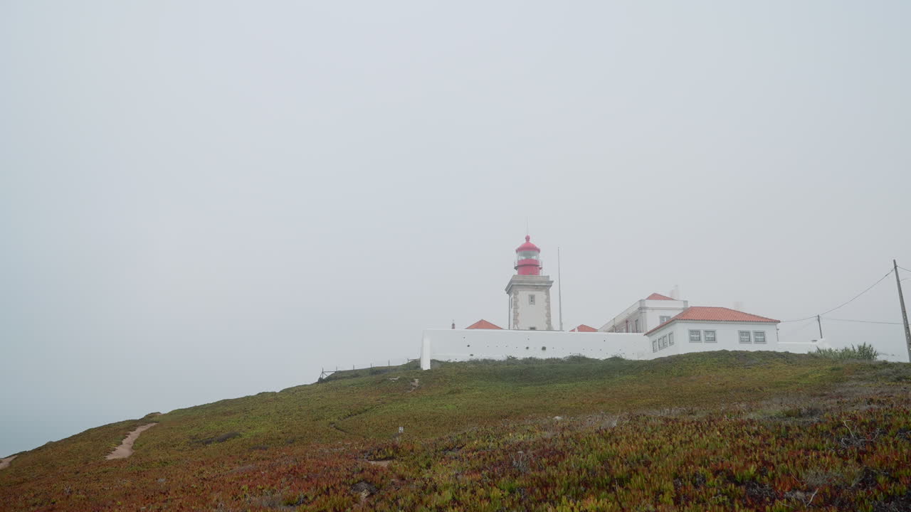 Lighthouse on a Foggy Coastal Hill