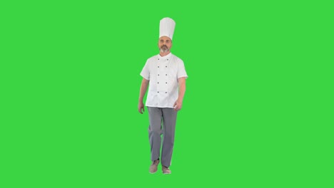 chef sénior en uniforme blanco caminando en una pantalla verde, llave de croma