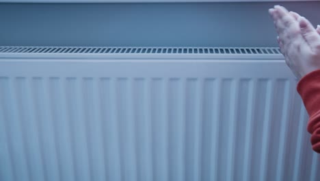 manos encendiendo la temporada de calefacción de cerca, la mujer haciendo la temperatura de la batería más tratando de mantenerse caliente en invierno