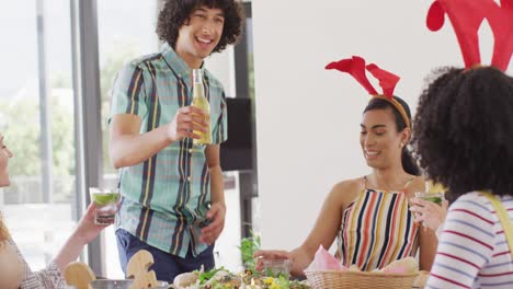 Feliz-Grupo-De-Amigos-Diversos-Sentados-A-La-Mesa-Y-Cenando-Juntos,-Haciendo-Tostadas