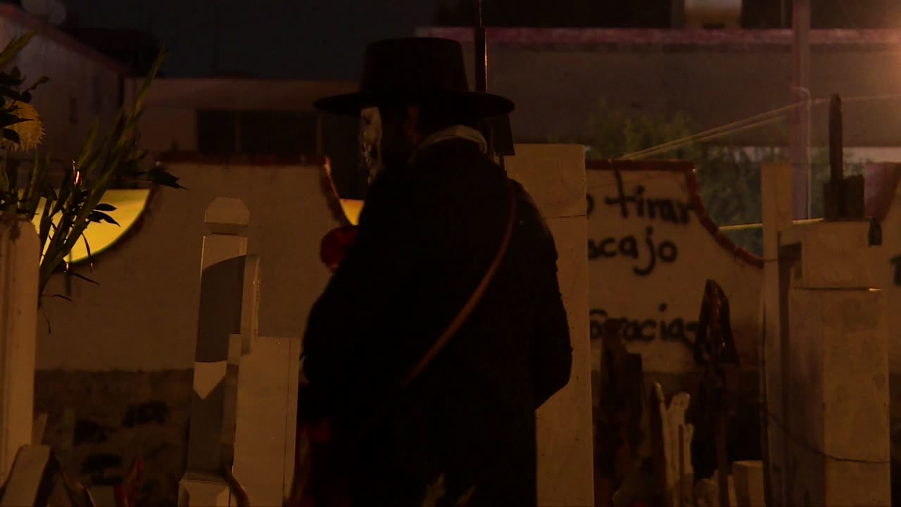 catrin esqueleto hombre con una catrina caminando en medio de un famoso cementerio en mixquic mexico