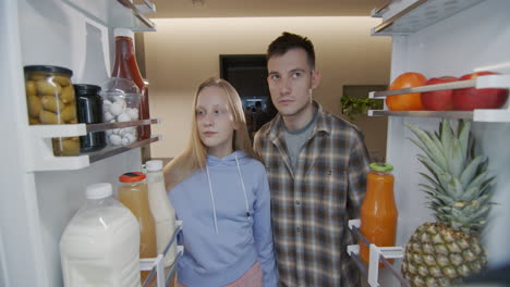 Hungry-teenagers-look-inside-the-refrigerator