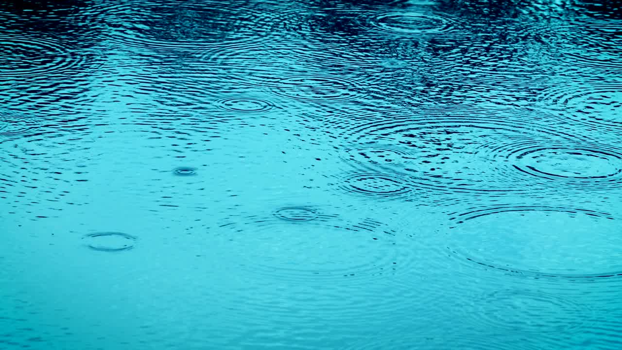 The Blue color tone of close up rain water drop falling to the river surface in rainy season , 4K Dci resolution