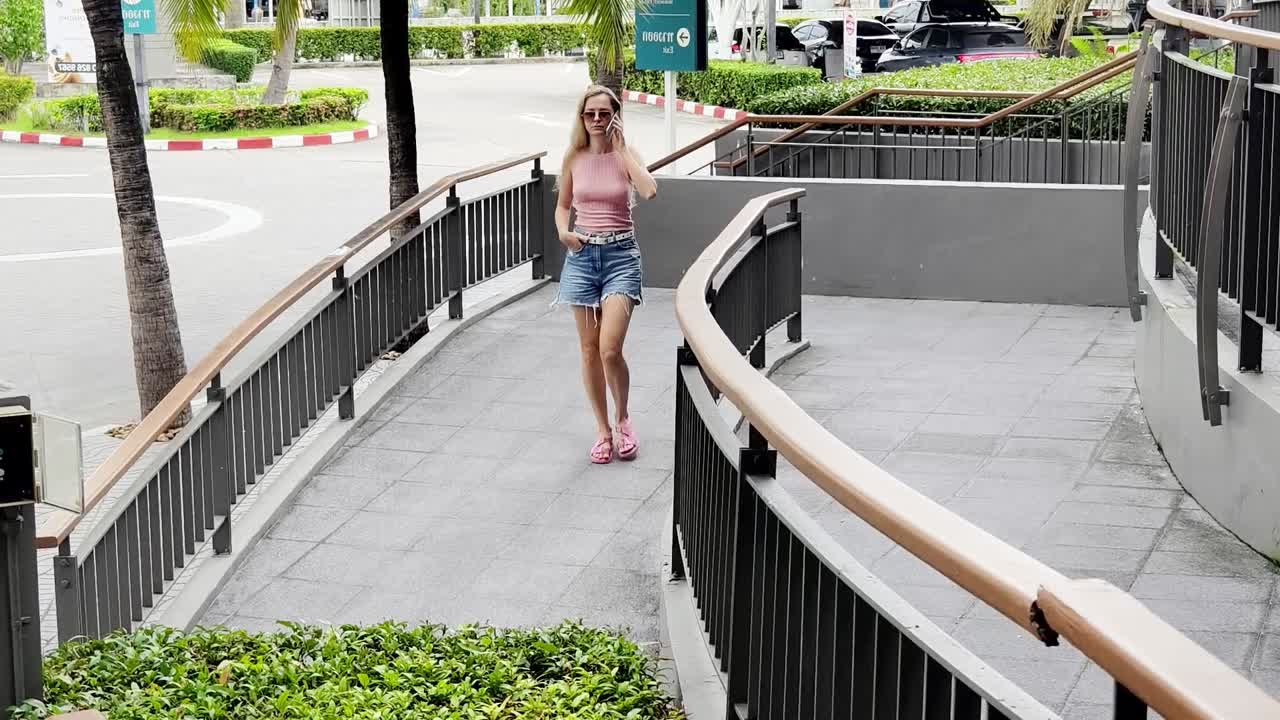 쇼핑몰 에서 여자 가 걸어서 전화 로 이야기 하고 있다