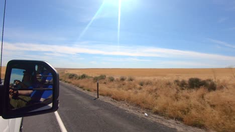pov fuera de la ventana del lado del pasajero mientras conduce a través de una zona agrícola del estado de washington oriental