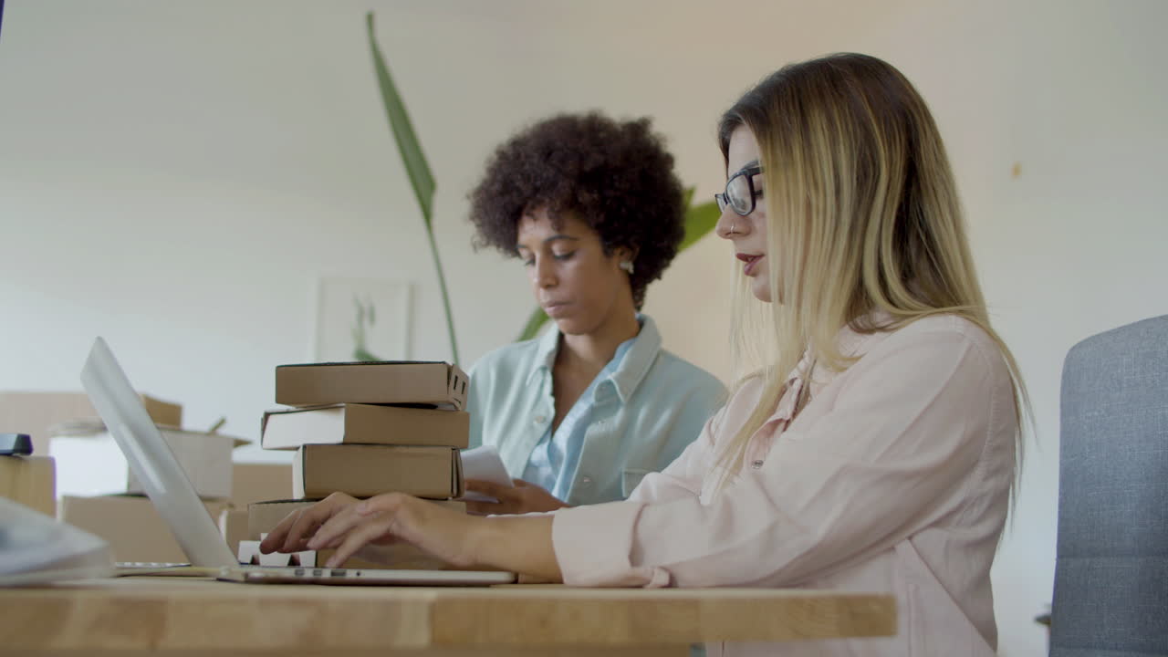 Two female colleagues working in office and talking