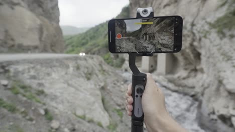 filmando un paisaje de montaña con un teléfono inteligente y un gimbal