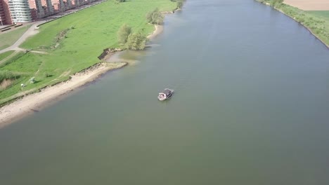 aerial footage of the boat crossing the river or canal in holland in 24 fps 4k