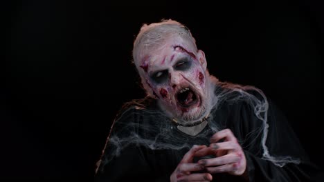 Unheimlicher-Mann-Mit-Schrecklich-Gruseligem-Halloween-Zombie-Make-up,-Der-Unter-Krämpfen-Gesichter-Macht-Und-Versucht,-Angst-Zu-Machen