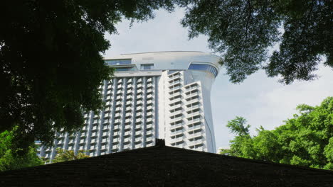 high-rise multi-story condominium real-estate properties seen from below, in between the surrounding trees