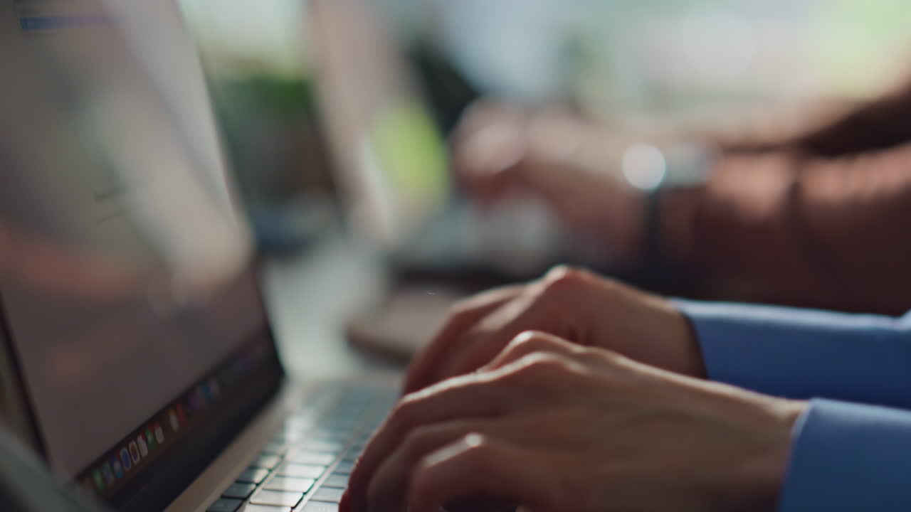 Closeup hands working laptops in busy office workspace. Unrecognizable employees