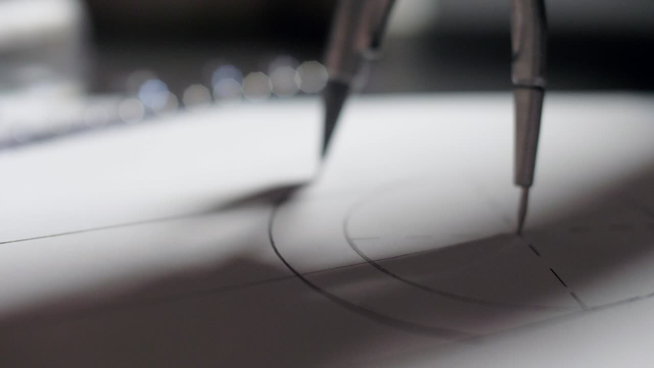 가까운 나침반은 종이에 메커니즘의 둥근 부분 세부 사항을 그립니다.