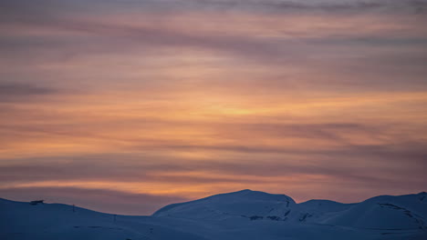 Zeitraffer-Von-Tag-Zu-Nacht,-Sanfte-Wolken,-Die-Sich-über-Die-Bergsilhouette-Bewegen,-Farbenfrohe-Sonnenuntergangsstimmung