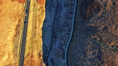distant car driving down a country road in the moors of the uk with barron landscape