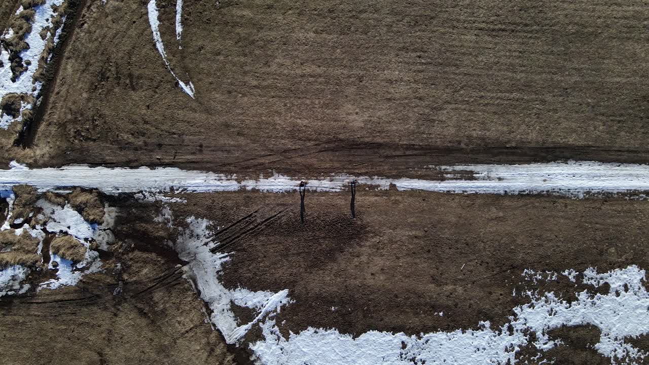 캐나다의 오지를 통해 스노우슈잉을 하는 커플의 조감도 드론 샷