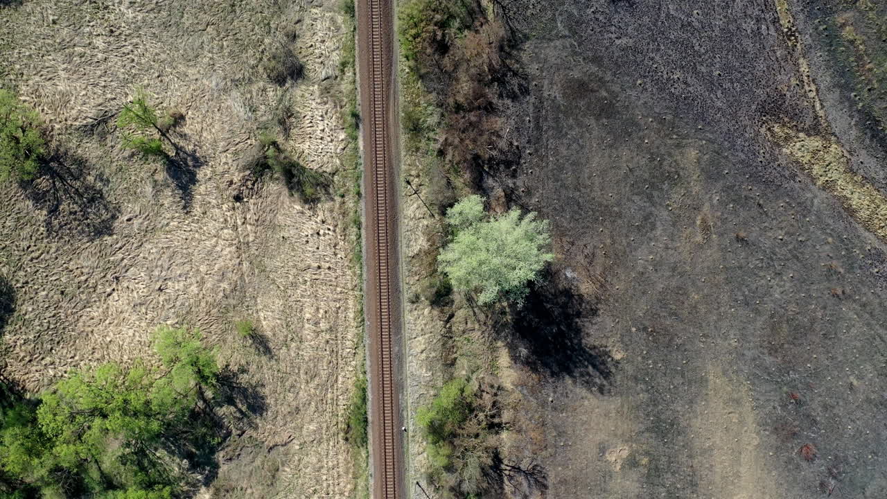 Train track through grass fields shot from high above