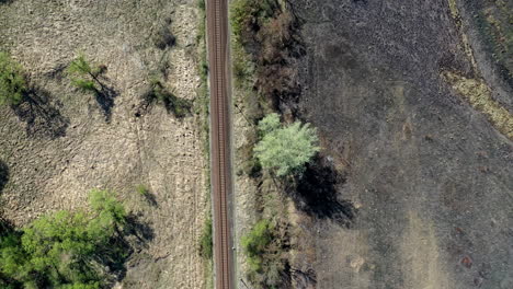 Train-track-through-grass-fields-shot-from-high-above