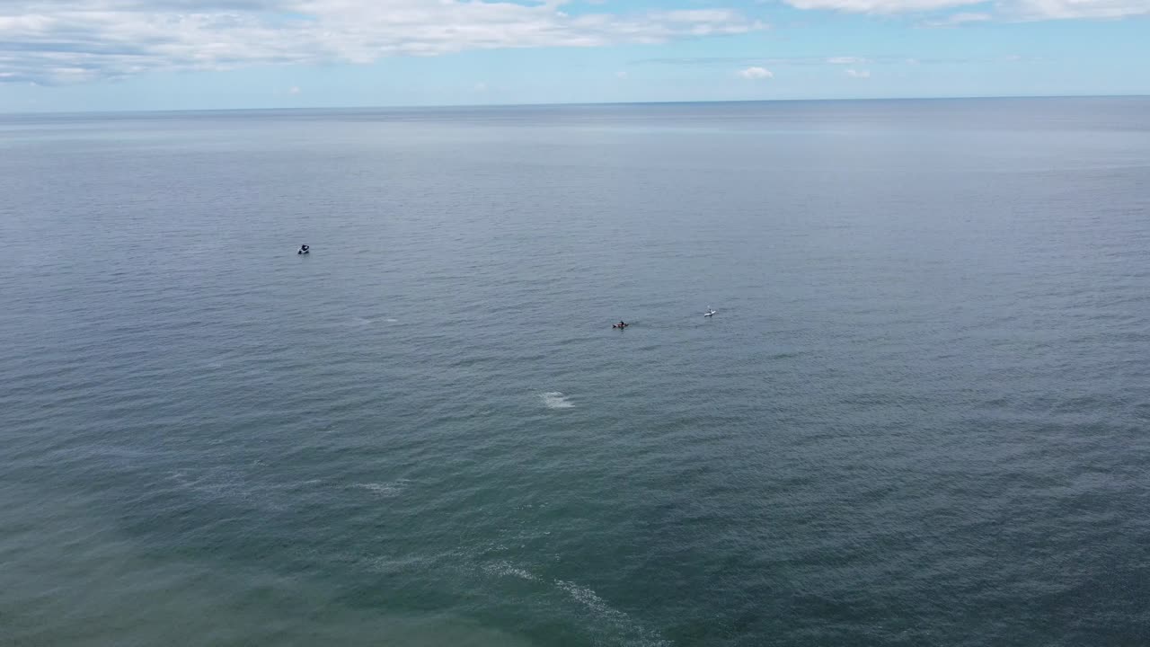해변 카약과 아래의 낚시 보트를 타고 내려오는 드론, 날아가는 새들