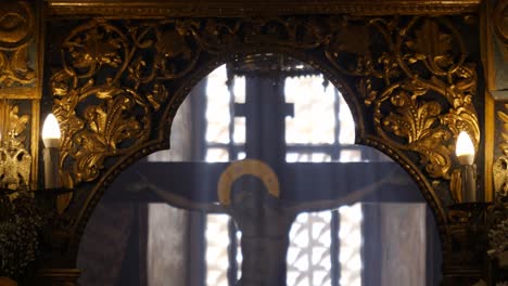 vista de la estatua del crucifijo de jesús en una iglesia griega con luz que se transmite a través de las ventanas