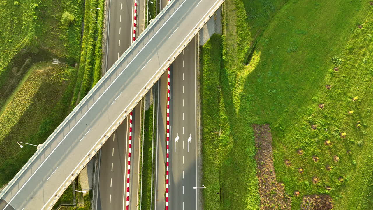 Striking top-down aerial view of a modern highway overpass intersecting the S6 expressway lanes, showcasing the geometry, with a single white car below