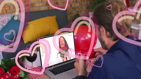 Animation-of-pink-hearts-over-caucasian-man-proposing-on-laptop-video-call