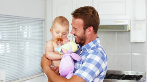 padre feliz sosteniendo y abrazando a su bebé