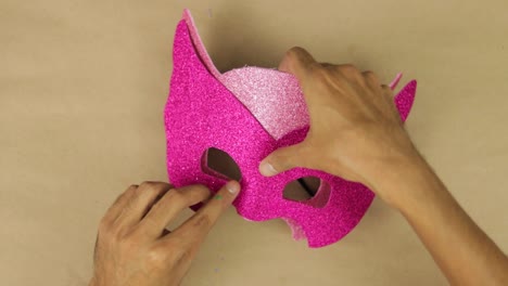 measure and glue pink color diamond foam with your hands, carnival mask