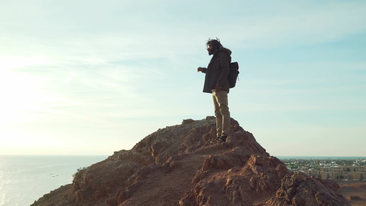hombre guapo de oriente medio con dreadlocks mirando hacia adelante al amanecer