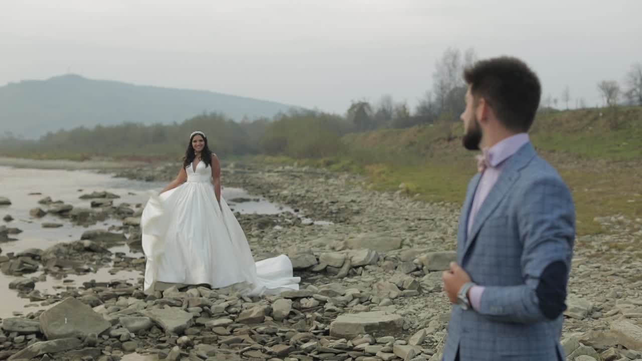 산 강 근처 에 서 있는 결혼 부부. 사랑 에 빠진 신랑 과 신부