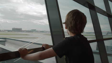 al joven viajero le gusta ver los aviones que salen en el aeropuerto