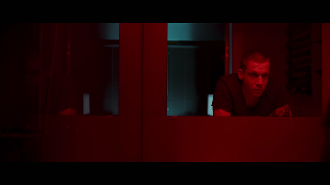 Sguardo intenso in una stanza illuminata di rosso.