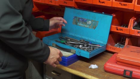 slow motion shot of an engineer opening an old tap and dye tool set in an engineering workshop