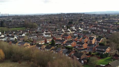 Rural-British-townhouse-neighbourhood-homes-with-green-space-aerial-view-across-to-Snowdonia-mountain-skyline,-slow-orbit-right