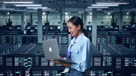 vista lateral de una mujer de negocios asiática usando una computadora portátil en un centro de datos