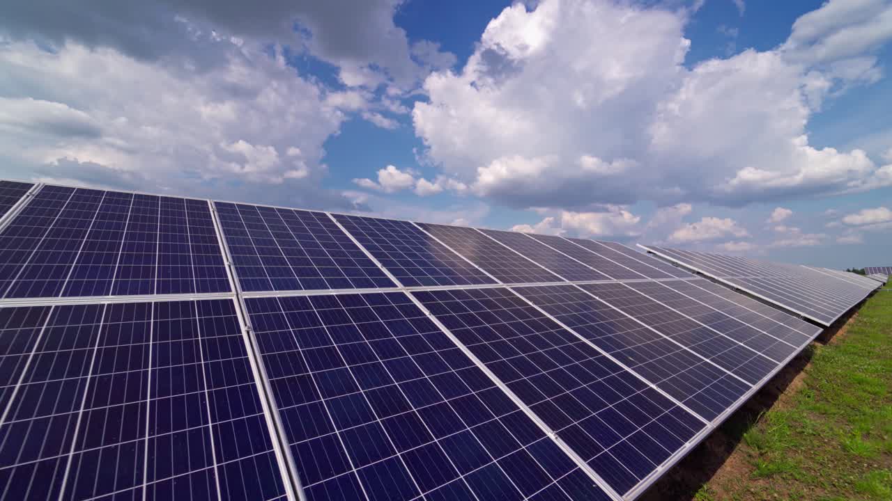 Solar panels on the grass. Solar panel electricity station for renewable green energy in summer. Long row of blue panels outdoors.