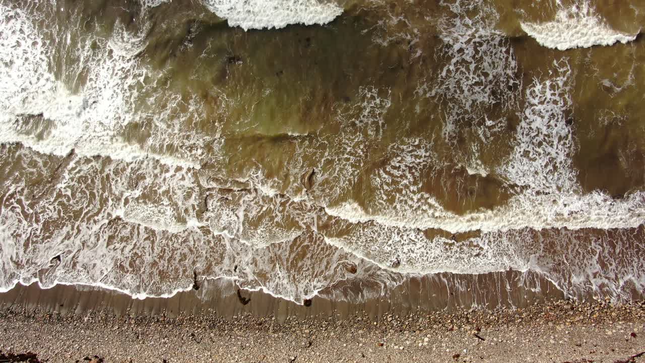 바위 같은 모래에 충돌하는 하얀 물결의 4k 정적 드론 샷