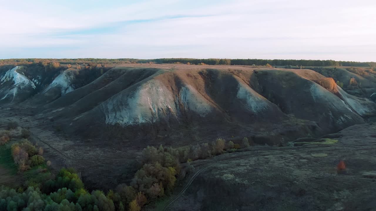 vista aérea de un valle con colinas y bosques erosionados