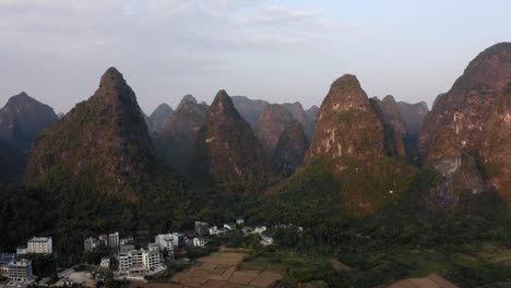 Ciudad-De-Yangshuo-En-Un-Hermoso-Paisaje-De-Montaña-Kárstica,-Vista-Aérea-De-La-Puesta-De-Sol