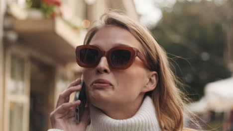 caucasian female having a call on smartphone outdoors.