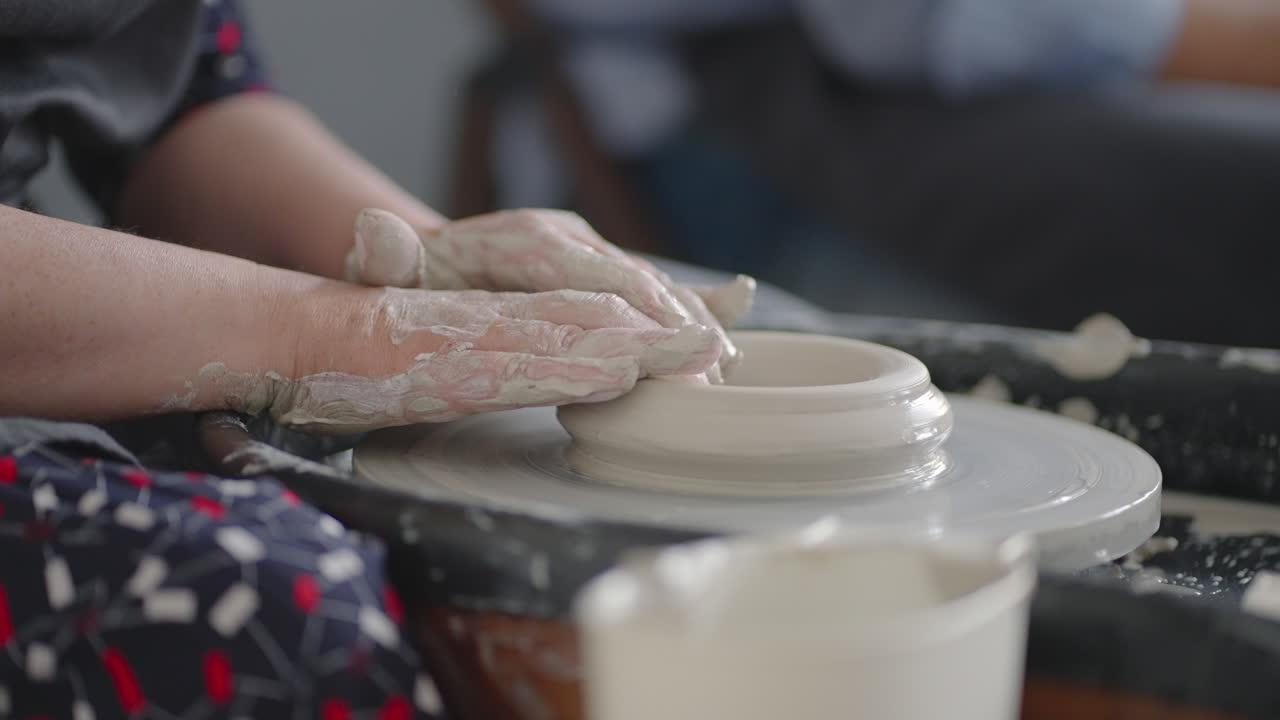 Close-up of the hand of a grumpy woman master works on a potter's wheel in slow motion. Making utensils with your own hands