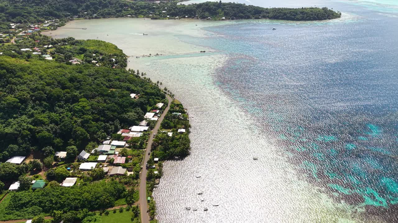 Isola di Bora Bora, Polinesia Francese. Ripresa con drone di strada in un villaggio costiero e laguna