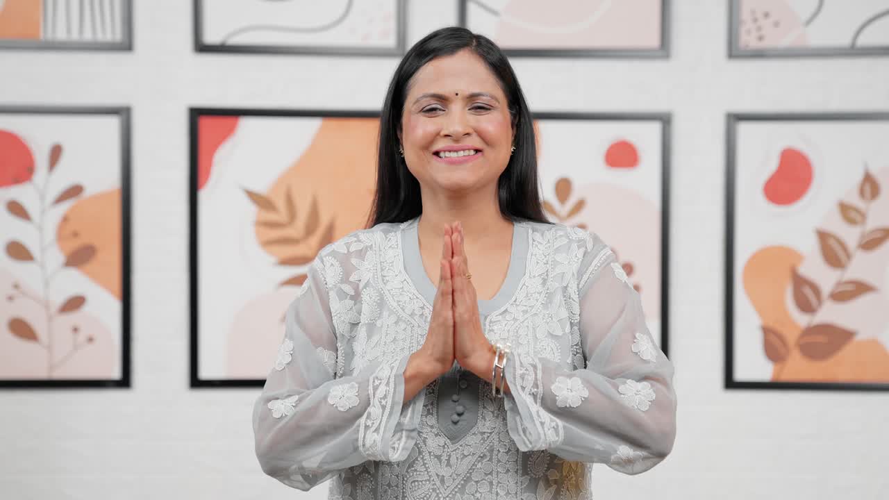 Indische Frau mittleren Alters macht Namaste