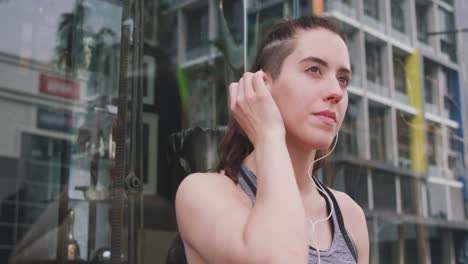 mujer caucásica escuchando música con auriculares