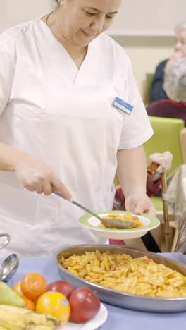 cook plating pasta serving food in a nursing home