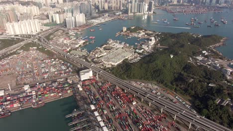 wide view of hong kong container terminal and port at victoria bay with storage terminal and docked ships, aerial footage