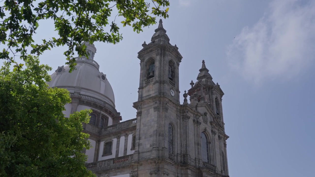 Torres sineiras de pedra e Cúpula Branca do Santuário do Sameiro Elevando-se Acima das Árvores em Braga.