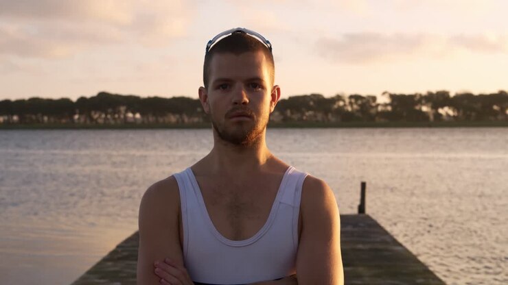 Kaukasisk roer står på en brygge og ser inn i kameraet