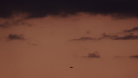 airplane in the sunset cloudy sky in slow motion