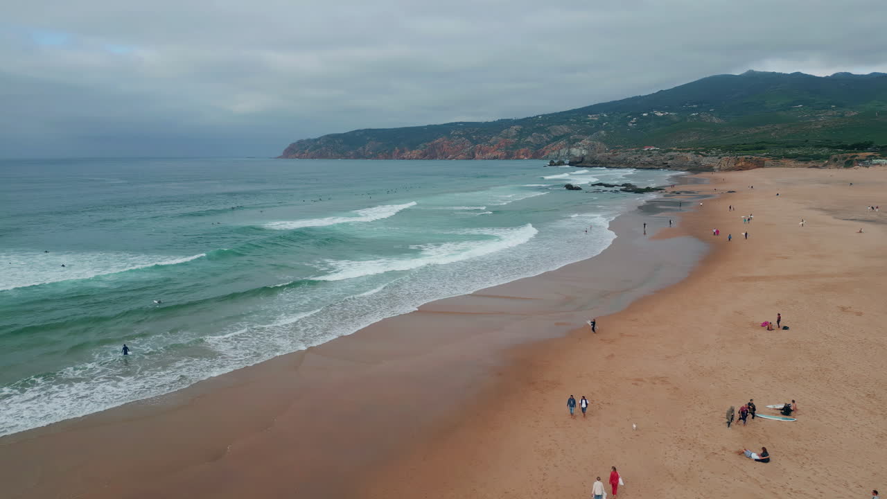 Cloudy sky sandy beach scene aerial view. Groups tourists surfers enjoy Atlantic