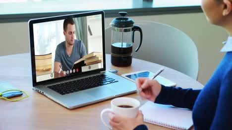 Caucasian-female-teacher-using-laptop-on-video-call-with-male-student,-making-notes